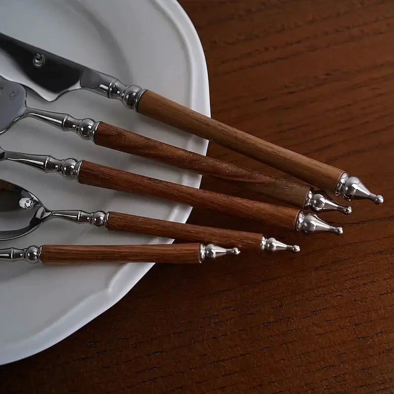 Ornate western tableware set with stainless steel blades and elegant brown wooden handles for dining room use