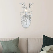 Ornate silver wall light fixture with crystal droplets and leaf embellishments designed for bedroom use