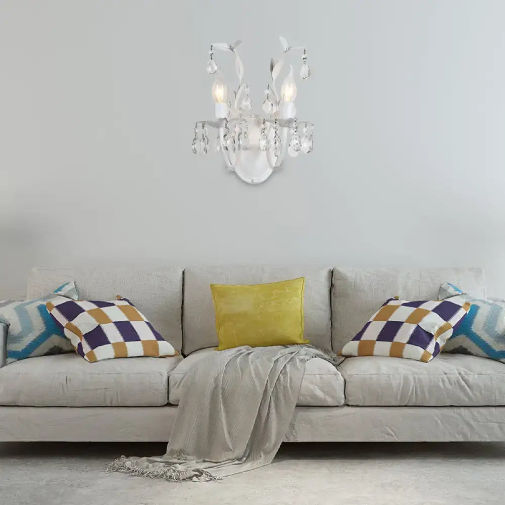 Ornate silver wall light fixture featuring a delicate white crystal chandelier with curved arms and teardrop crystals