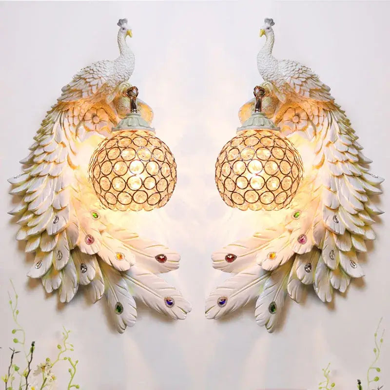 Ornate white gold peacock crystal wall lamp pair with detailed feather designs and warm-toned spherical glass shades for decorbites gold peacock decor