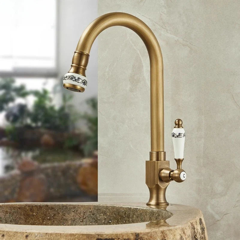 Antique brass single hole outdoor antifreeze faucet with curved swivel spout and ceramic black floral handle accents