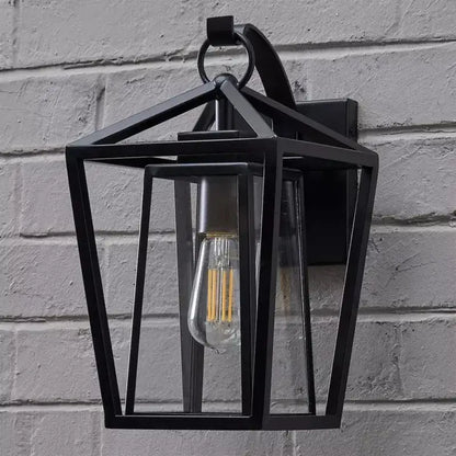 Black wrought iron outdoor wall light with clear glass shades and visible filament bulb by DecorBites
