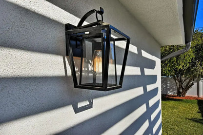 Black wrought iron outdoor wall light with glass shades and filament bulb for waterproof outdoor use