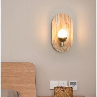 Warm-toned oval led wooden wall lamp with brass base and frosted glass bulb by decorbites for bedroom decor