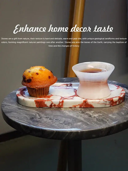 Rectangular white calacatta marble vanity tray with red veining holding a muffin and pinkish-white ceramic teacup decorbites calacatta marble