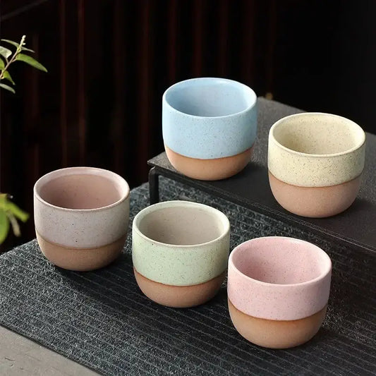 Set of five ceramic tea cups with speckled pastel tops and terracotta bases in a tea cup set for dining room use