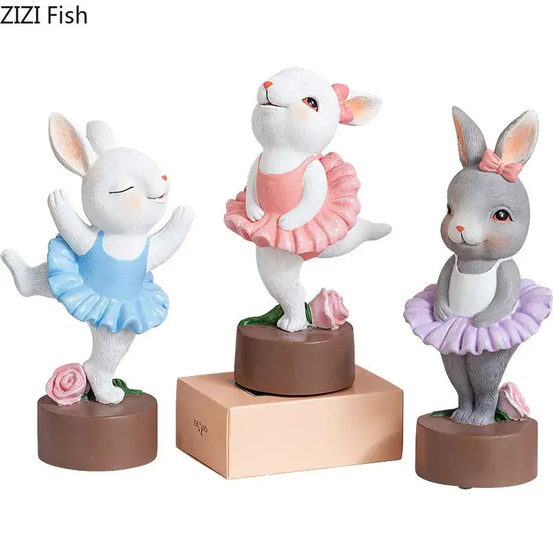 Three resin ballet rabbit dancer sculptures in pastel tutus on brown bases for bedroom desk decor
