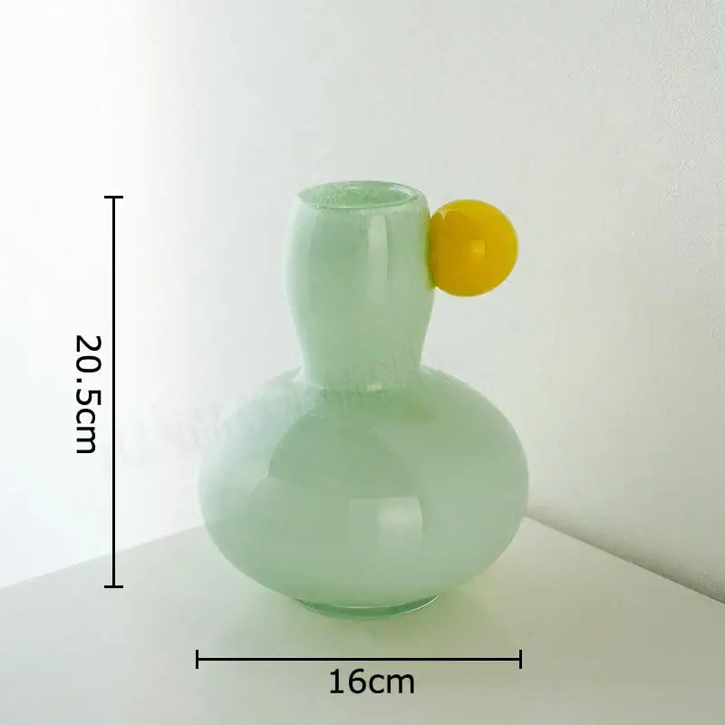 A translucent mint green ball glass vase with a bright yellow accent, ideal for decorbites colorful ball living room decor
