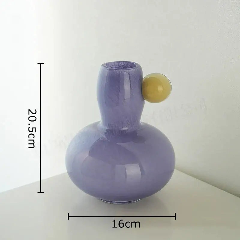 A sleek pastel blue and lavender colorful ball glass vase with a yellow handle for living room decorbites decor