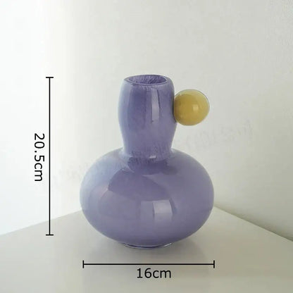 A sleek pastel blue and lavender colorful ball glass vase with a yellow handle for living room decorbites decor