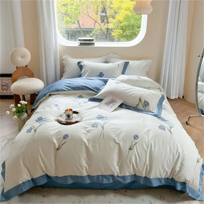 Cream-colored duvet cover with delicate blue floral embroidery and piping from pastel blue and peach colorful bedding set
