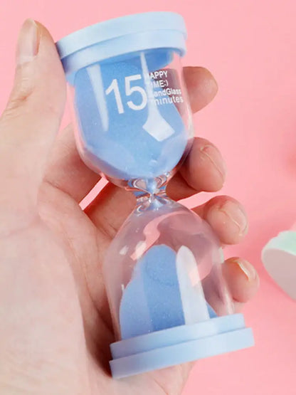 Pastel blue glass sand timer with light blue plastic lid marked 15 happy minutes in a kids bedroom timer set