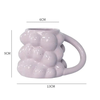 A matte lavender pastel bubbly grape ceramic mug with textured bubble surface and speckled finish for kitchen use