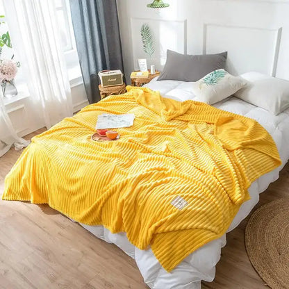 Bright yellow ribbed decorbites cozy hug blanket with soft plush texture and small woven label on corner