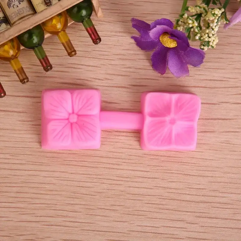 Pink silicone five petals flower mold with two square sections connected by a central bar for baking use
