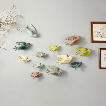A collection of colorful pastel flying bird ceramic wall ornaments in mint green peach yellow and gray for living room decor