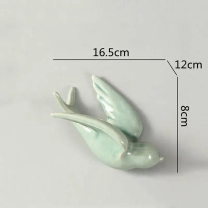 Delicate light green pastel flying bird ceramic wall ornament with glossy finish and gracefully curved wings for living room decor