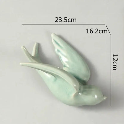 A delicate light green flying bird ceramic wall ornament with smooth glossy glaze and gracefully curved wings for living room decor