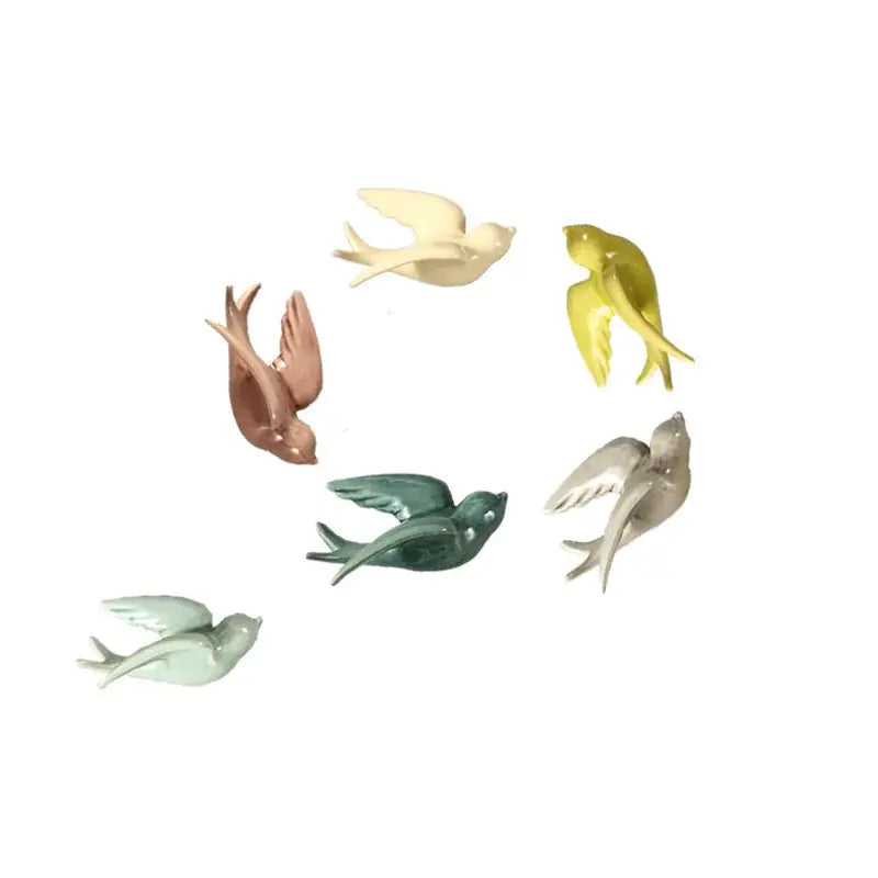 A set of six colorful glossy flying bird ceramic wall ornaments in pastel hues for living room decor