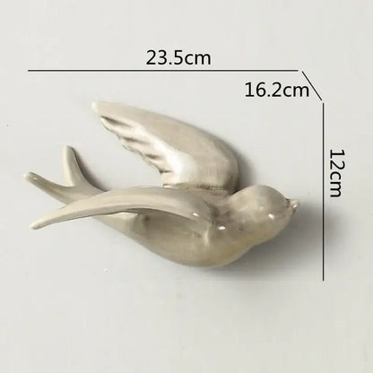A sleek off-white flying bird ceramic wall ornament with glossy finish and detailed wing feathers for living room decor