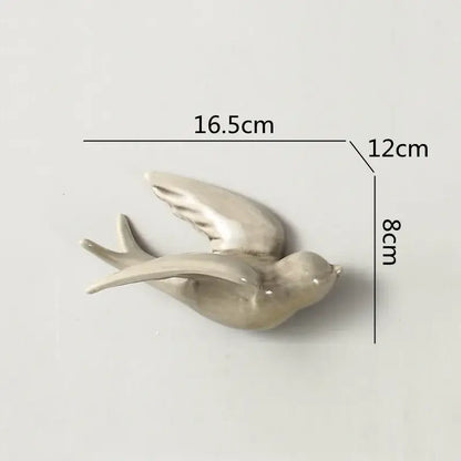 A sleek grayish-white matte flying bird ceramic wall ornament with smooth curves for living room decor