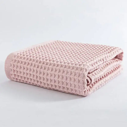 A soft pink decorbites cotton waffle bath towel with a textured grid pattern from the pastel multi color set