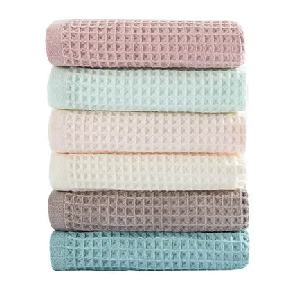 Stack of six pastel multi color decorbites cotton waffle bath towels in soft pink mint green blush peach cream white muted gray and teal blue