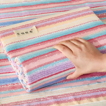 A folded pastel pink and blue decorbites cotton striped fitted sheet with soft textured cotton weave for bedroom use