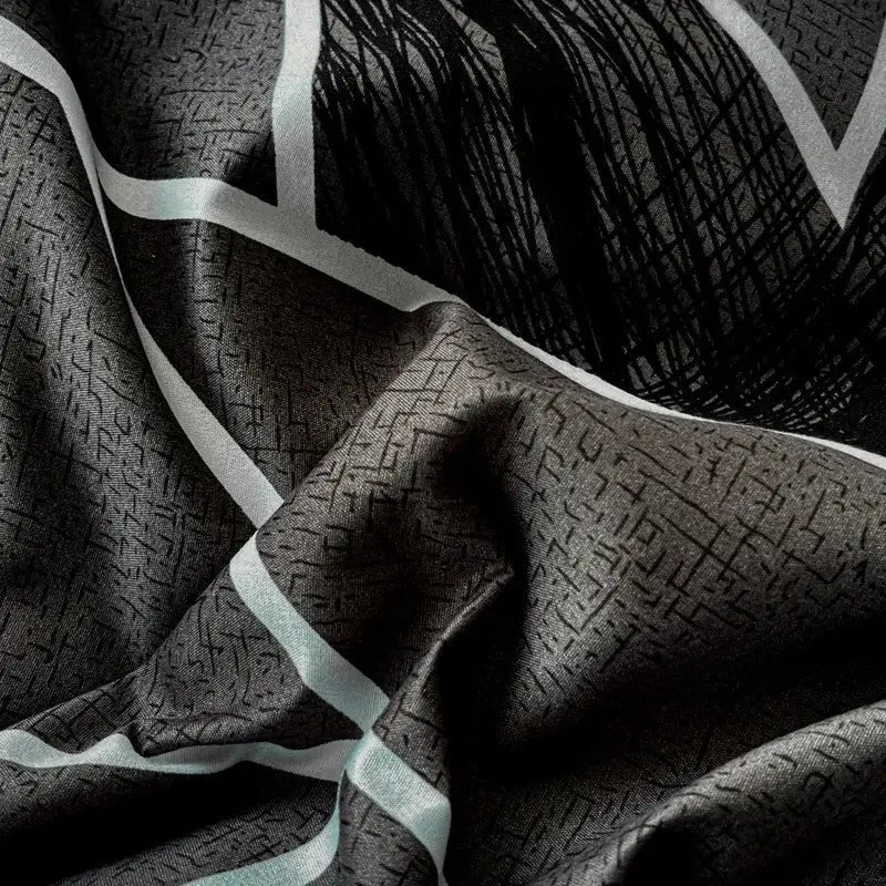 Black silk scarf with subtle geometric pattern and bold white stripes complementing decorbites cozy cotton bedding set
