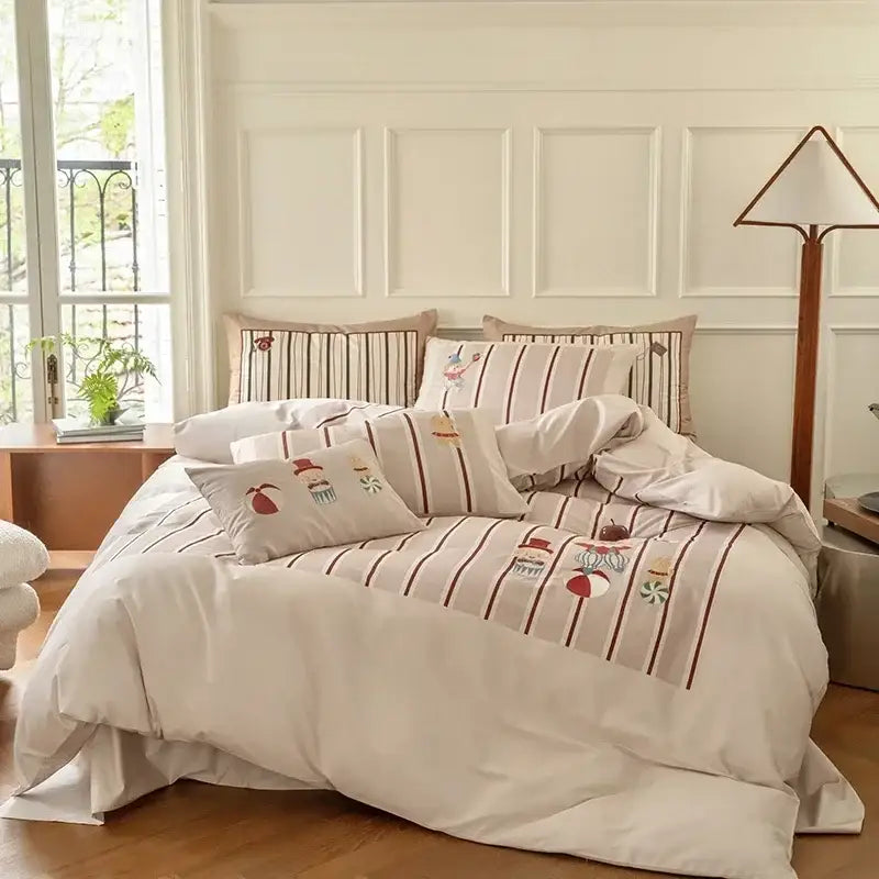 Cream-colored decorbites cotton embroidered bedding set with vertical brown stripes and dessert-themed motifs