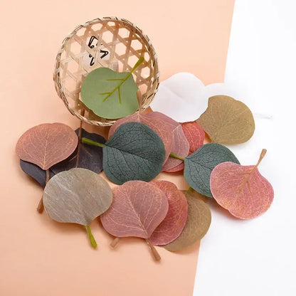 A collection of pastel pink and green silk leaf artificial plants with multicolored paper leaves for home decor