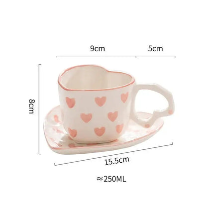 A white ceramic heart-shaped 250ml coffee cup with pink hearts and matching saucer from pastel polka dot set