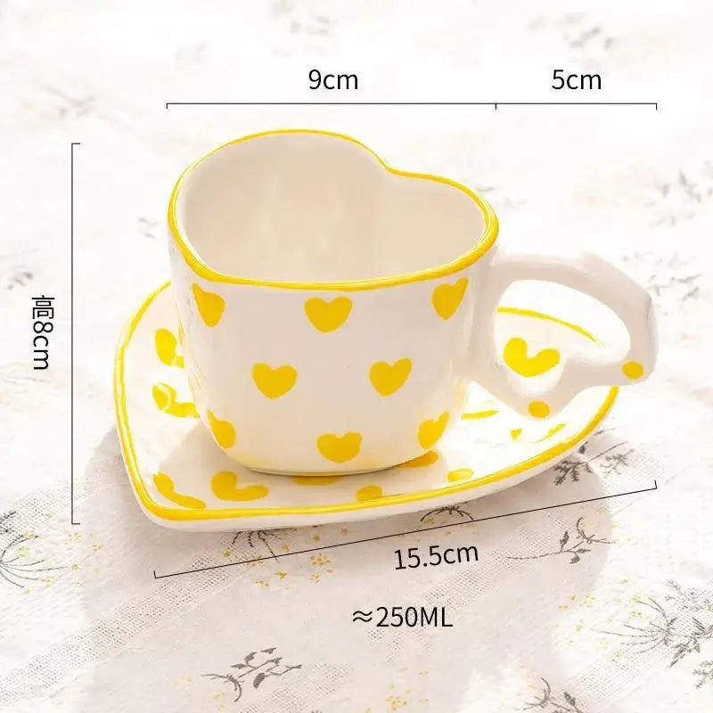 White ceramic heart-shaped 250ml coffee cup with yellow polka dots and matching saucer in glossy finish