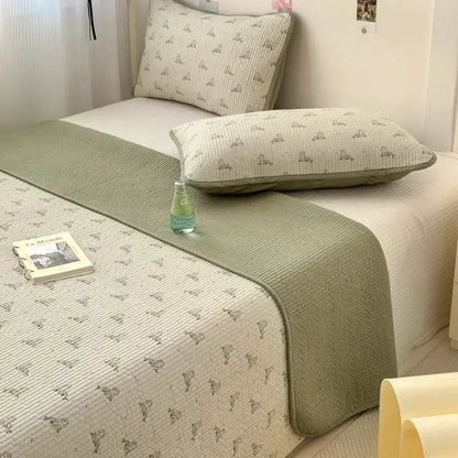 A soft sage green quilted cotton bed cover with subtle animal patterns designed as an anti-slip tatami mat