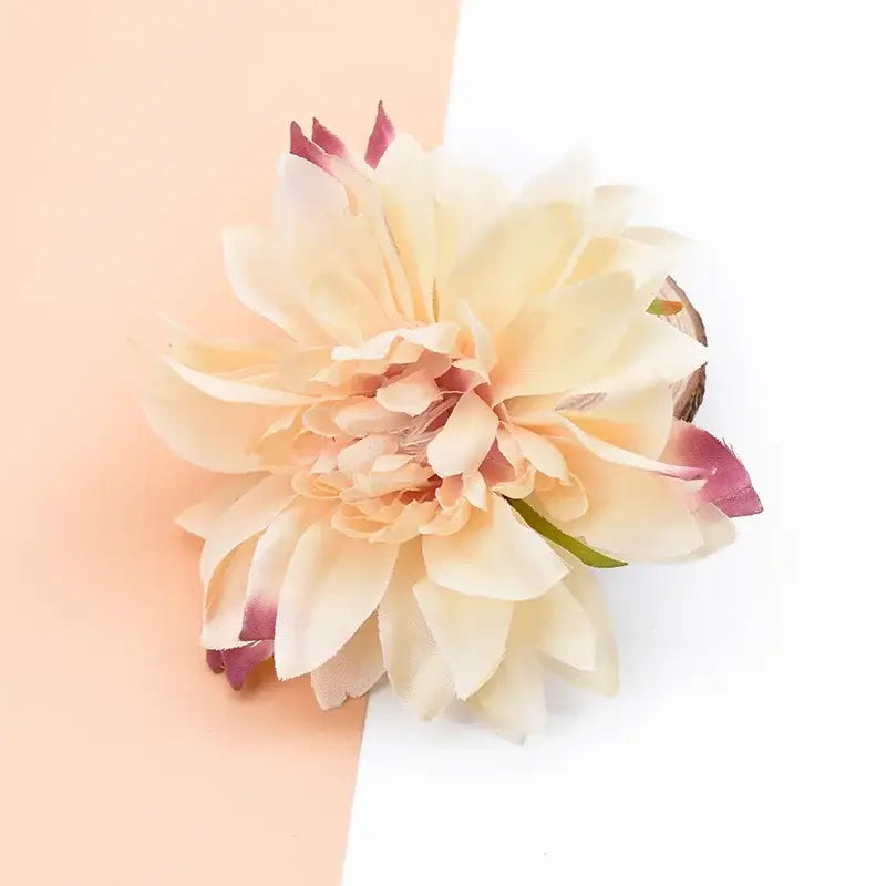 A delicate peach-colored silk gerbera decorative flower with soft layered petals and pink tips for wedding decor