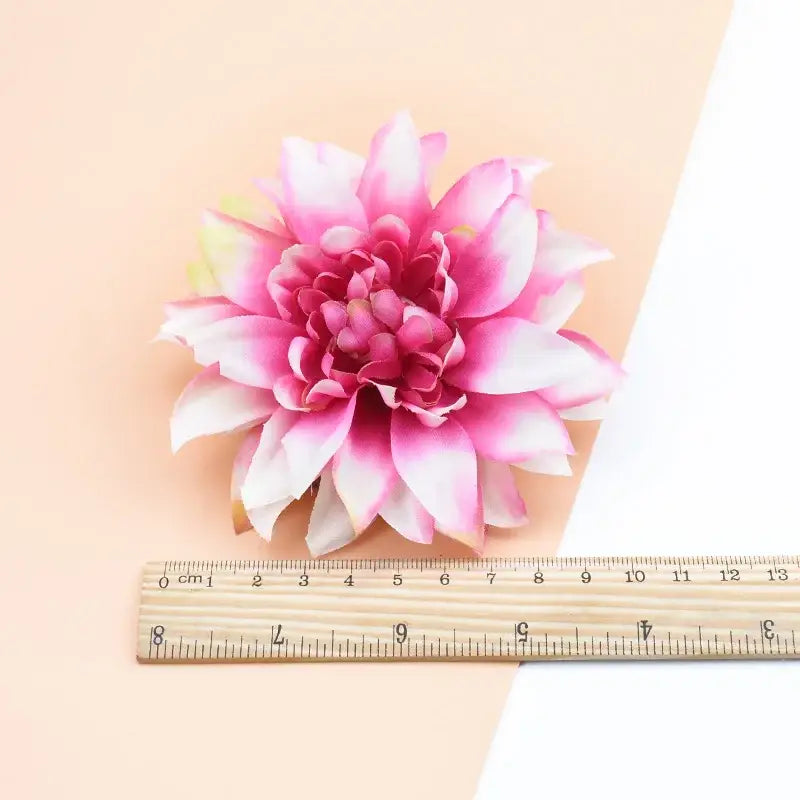 A vibrant pink and white silk gerbera flower with layered synthetic fabric petals for wedding and living room decor