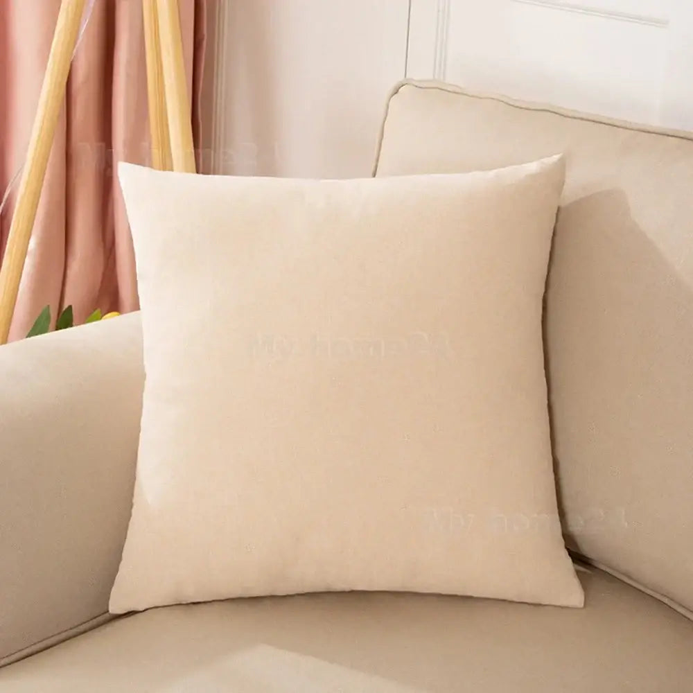 Cream-colored velvet square pillow on beige sofa as part of a pastel velvet pillow cover set for living room decor
