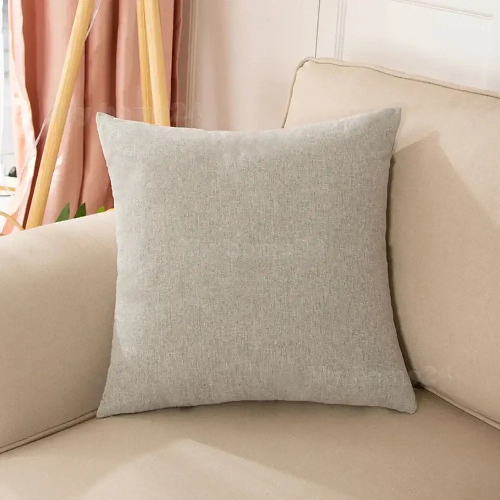A soft gray linen throw pillow on a beige couch from a pastel velvet pillow cover set for living room decor
