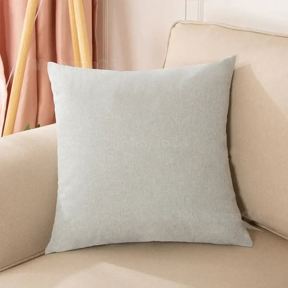 A soft light gray linen pillow cover with subtle texture on a beige couch from a pastel velvet pillow cover set