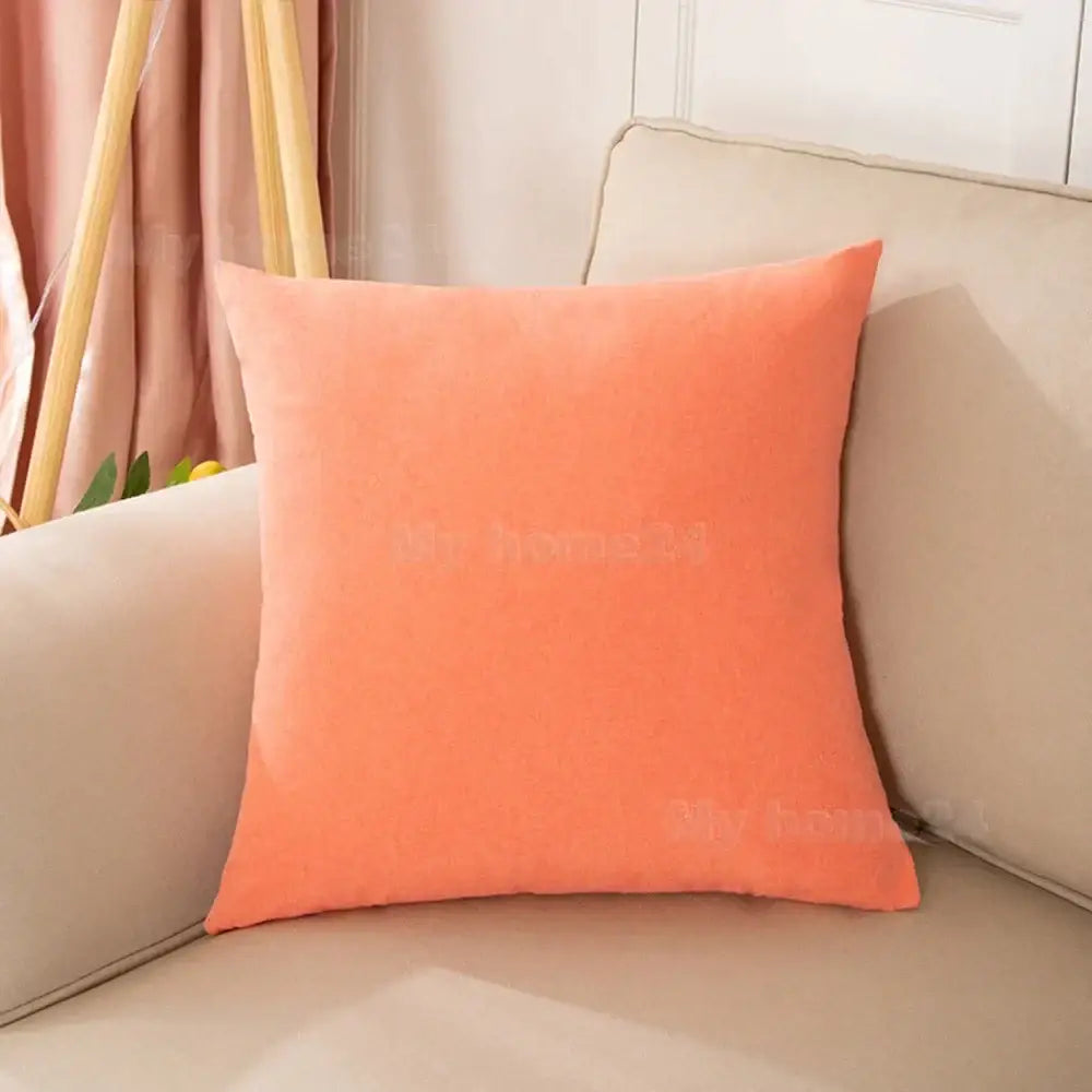 A soft coral velvet pillow cover set features plush texture on a beige sofa for living room decor