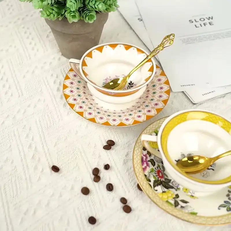 White porcelain flower coffee cup and matching gold rimmed coffee cup saucers with ornate orange design for tea time