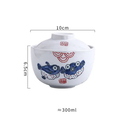 White ceramic stew pot bowl with matching lid featuring hand-painted blue pufferfish and red decorative dots