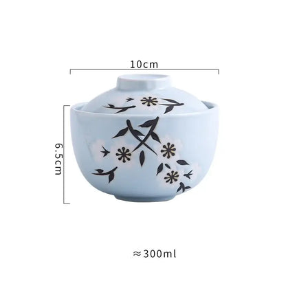 Light blue ceramic stew pot bowl with matching lid featuring black floral and bird motifs for dining use
