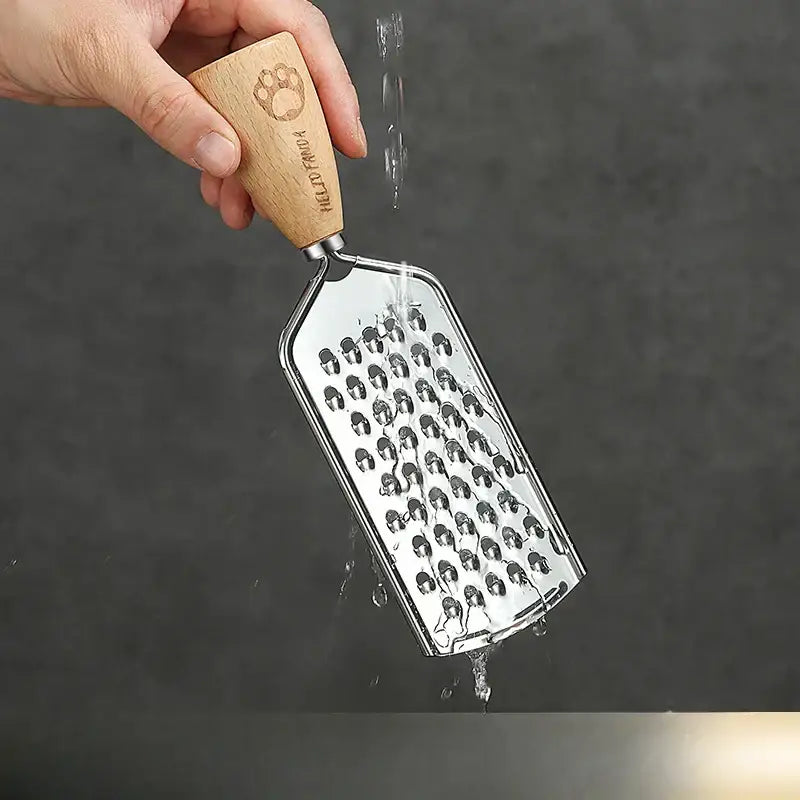 A stainless steel 3-in-1 multifunctional grater with a wooden handle engraved with a paw print and hello panda branding