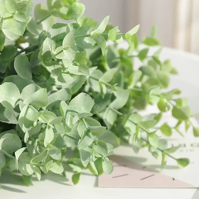 A delicate peach and green eucalyptus leaves artificial arrangement with soft light green decorbites eucalyptus leaves stems in a living room vase