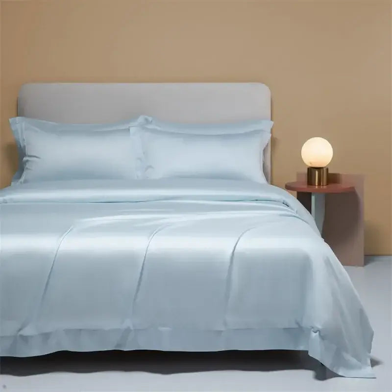Light blue satin bedding set with matching pillows featuring a cooling cotton solid finish for bedroom use