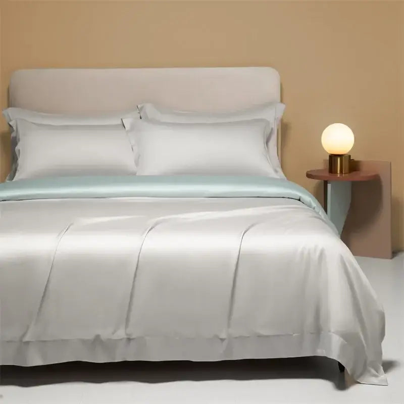 A sleek satin textured cooling cotton solid bedding set in soft white with a subtle mint green border for bedroom