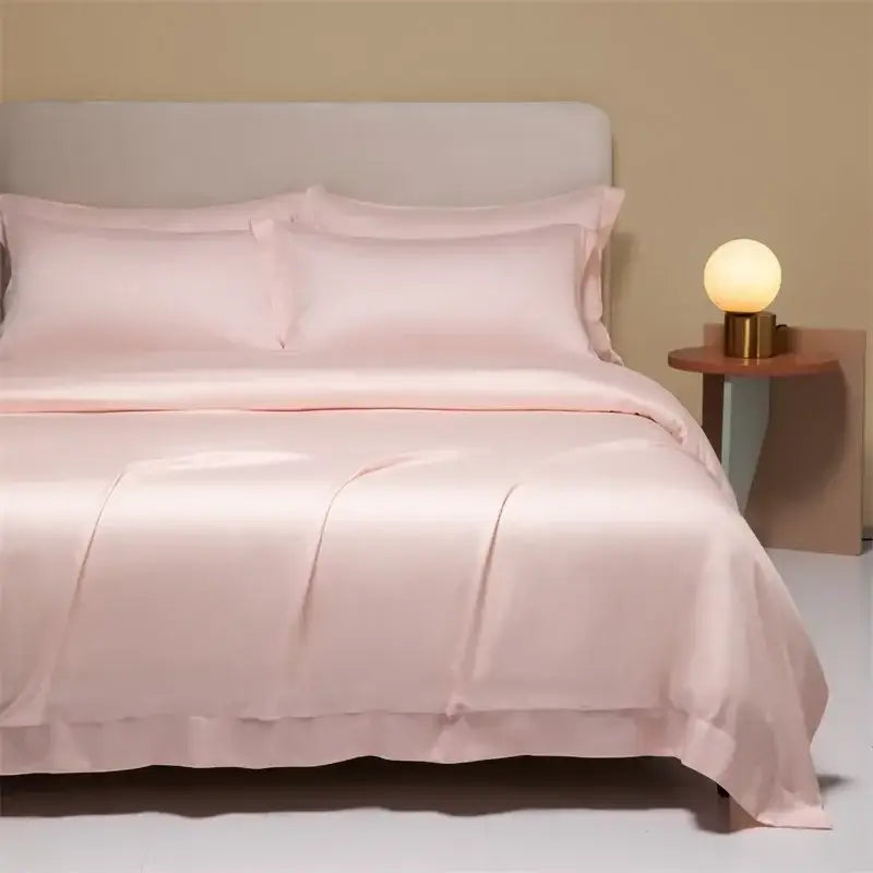Soft blush pink satin bedding set with ruffled edge and matching pillows in peach satin cooling cotton solid design