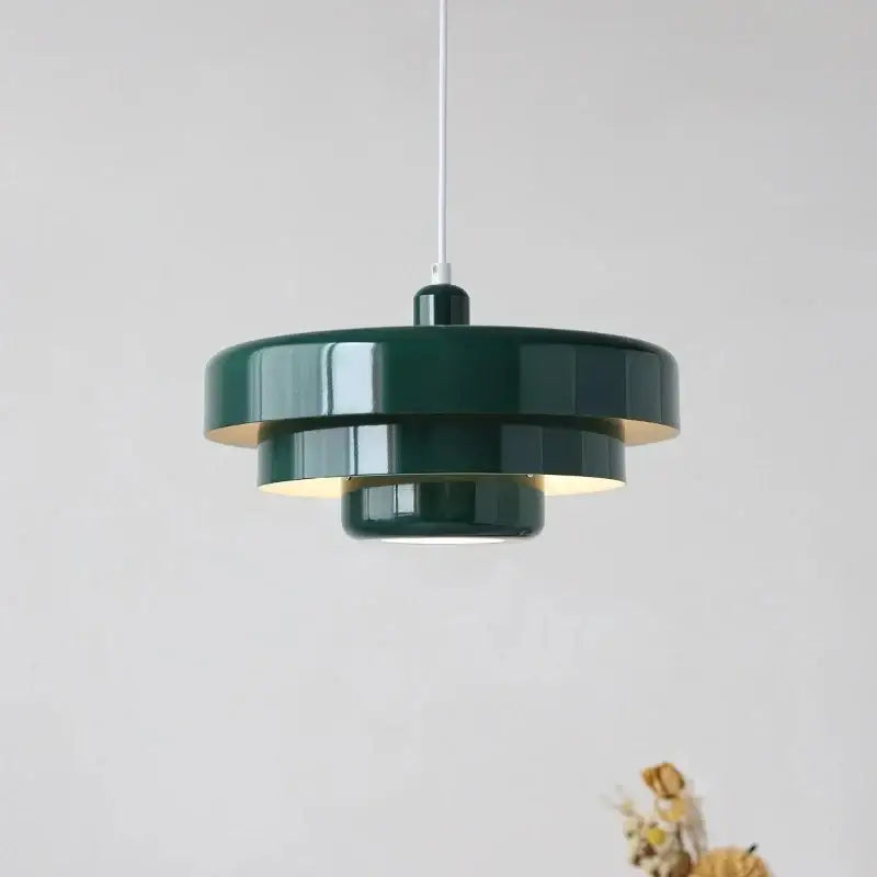 Dark green tiered pendant lighting with glossy finish and warm interior glow in bauhaus style retro pendant lamp design