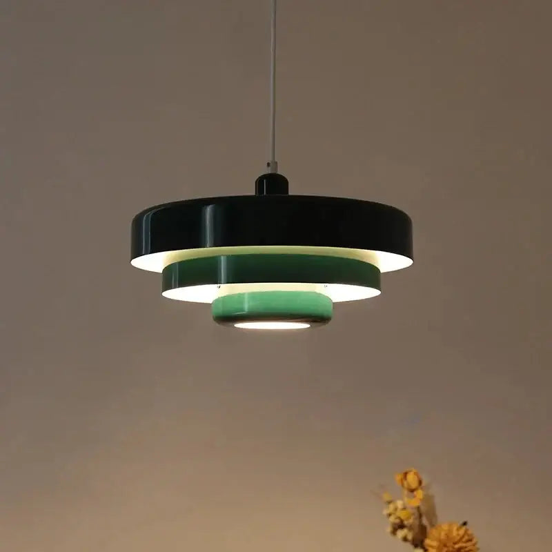 Modern tiered pendant lighting with concentric glossy black and matte green rings emitting warm glow retro pendant lamp